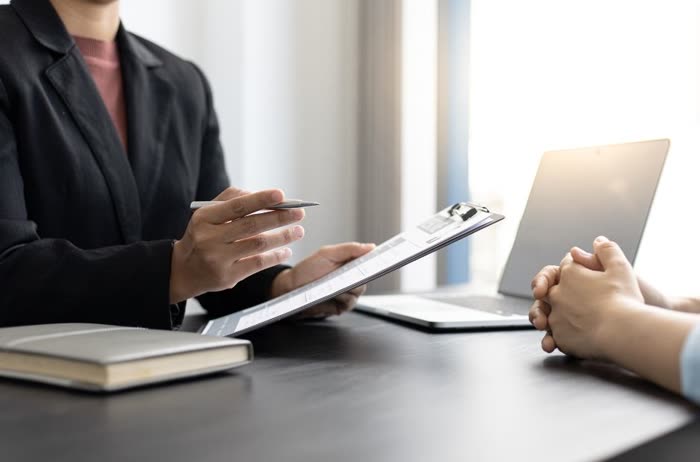 Profissionais conversando sobre documentos em uma mesa